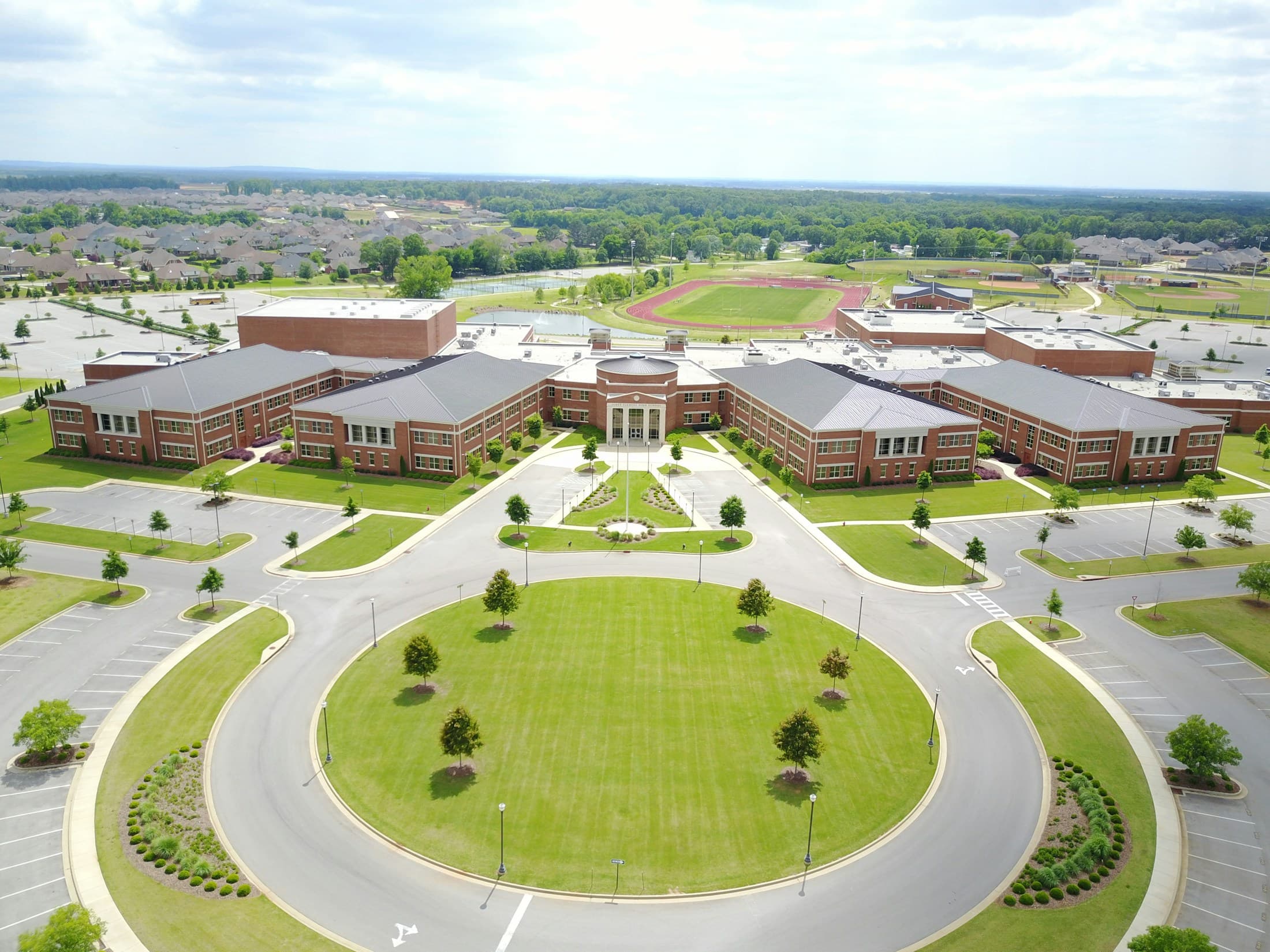 A brick secondary school campus in Madison, United States, surrounded by green spaces and athletic fields