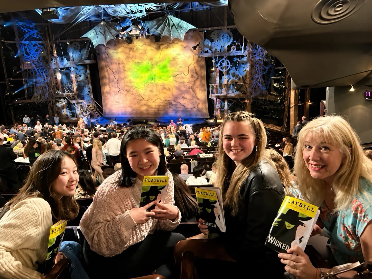 Students seated together with theatre programs before a performance