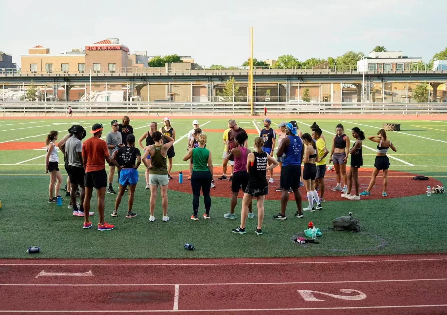 Students gathered in a circle on an athletics field