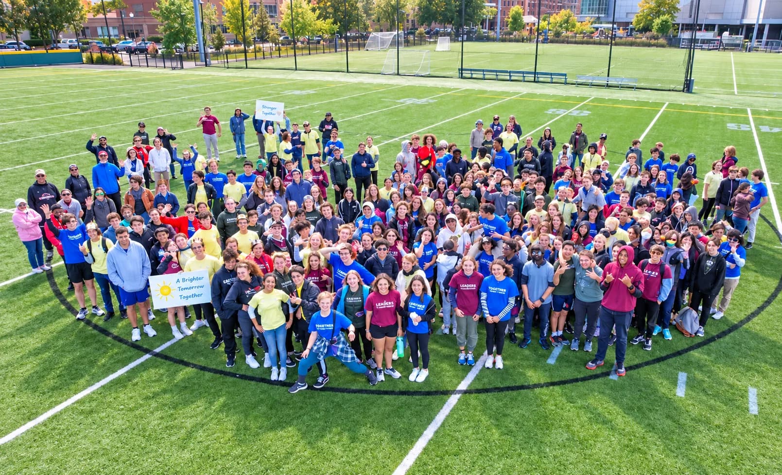 A large group gathered together on a school playing field